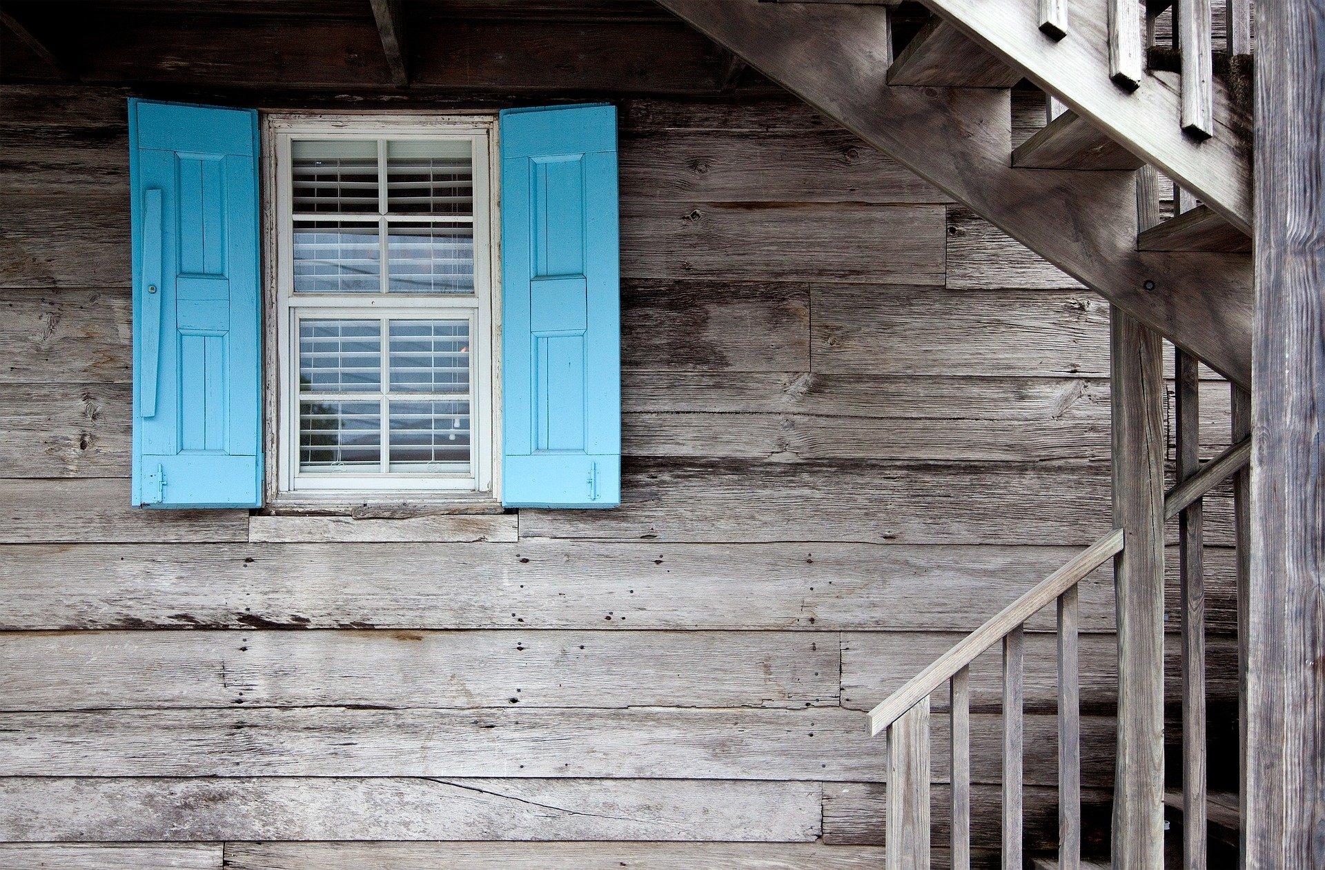 wood wall with window and blue shutters